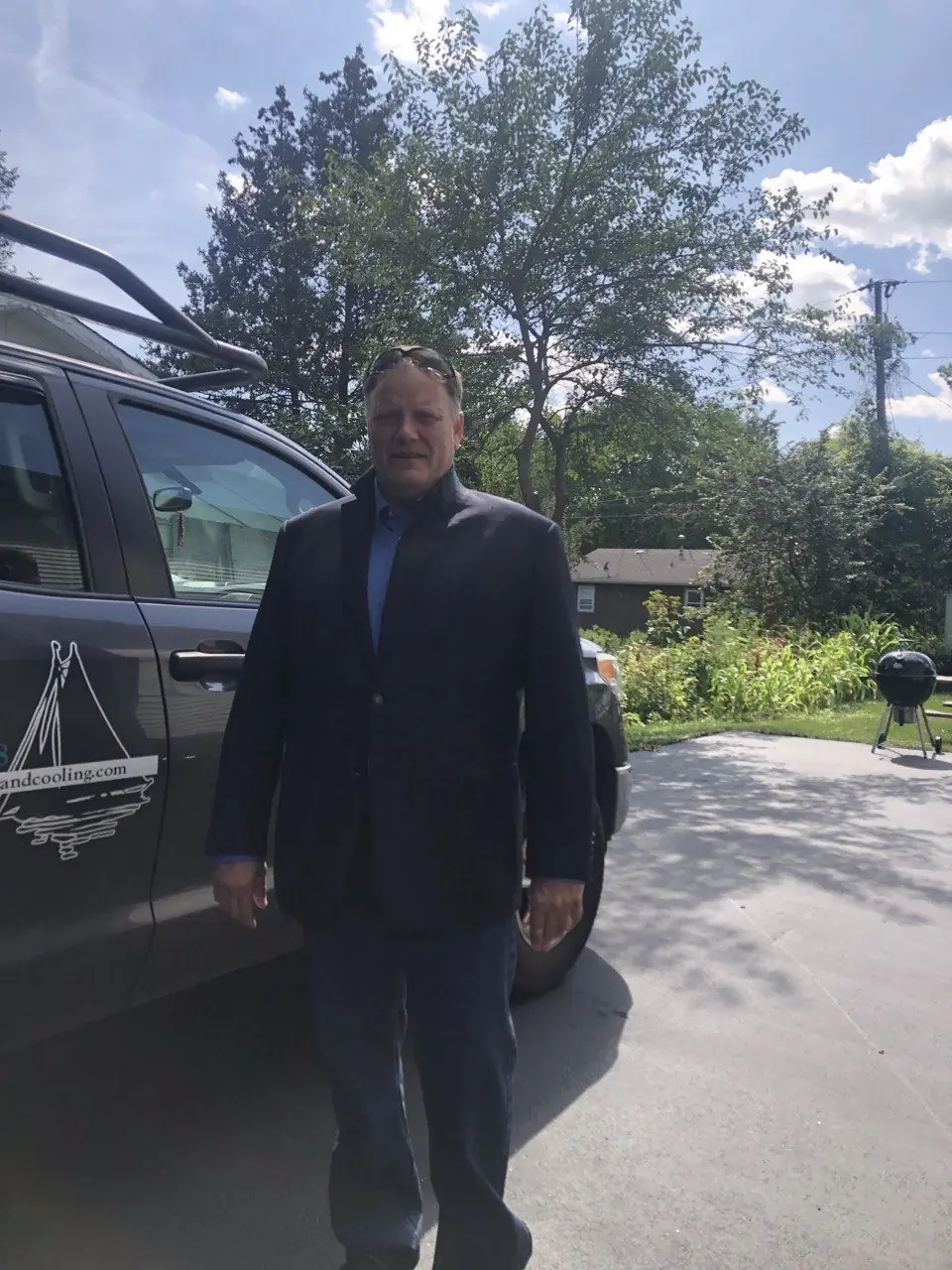 Michael D. Godfrey beside a Lake Geneva Heating and Cooling company truck